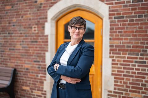 Dr. Treadwell with arms crossed in front of orange framed doorway